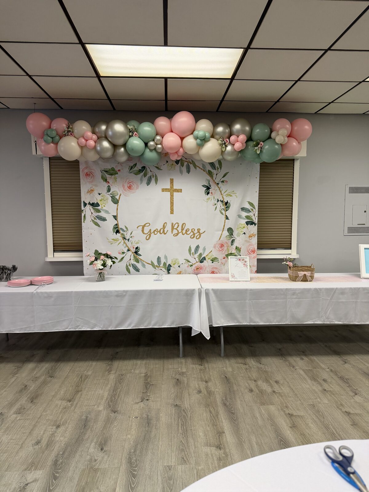Christening backdrop with pastel balloons and greenery
